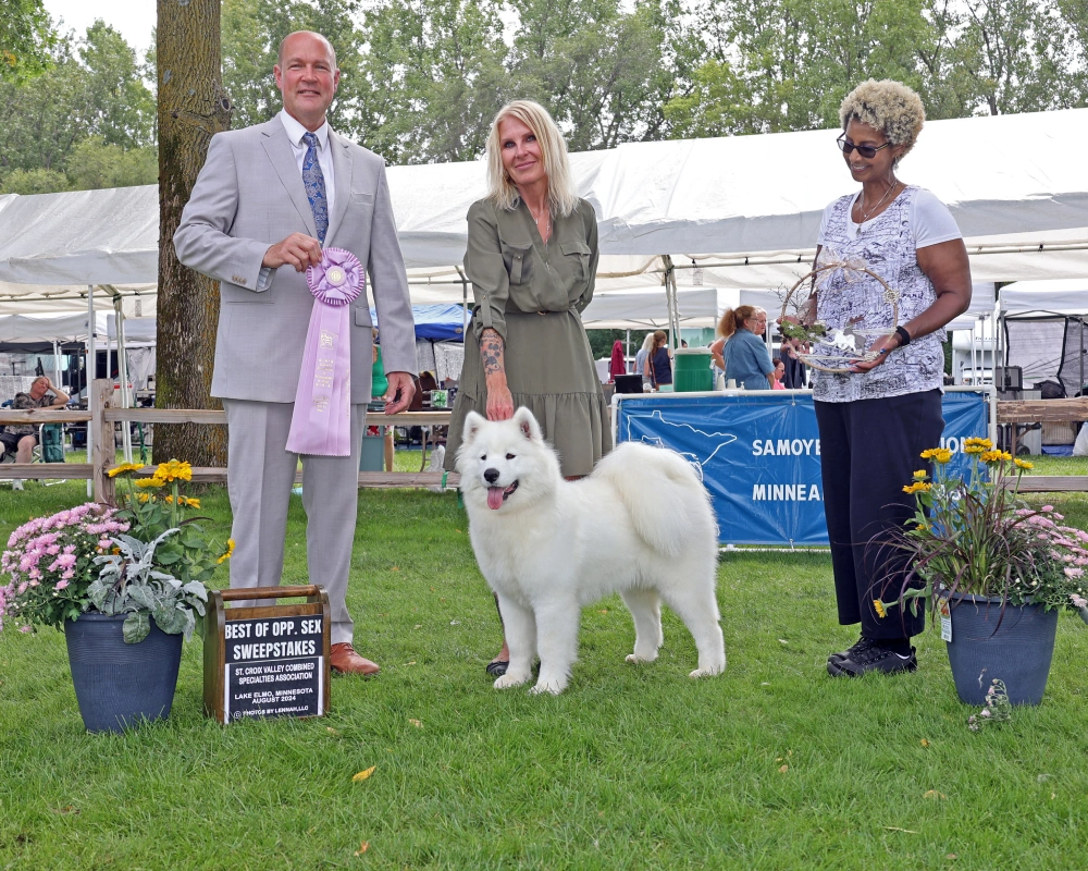 A group of people standing around with a dog.